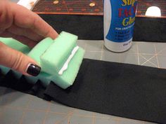 someone is making something out of foam on the edge of a piece of fabric and glue