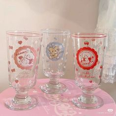 three glasses sitting on top of a pink table