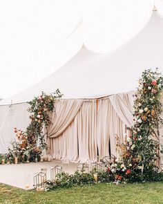 an outdoor wedding tent with flowers and greenery