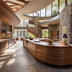 a large kitchen with an island and spiral staircase leading to the upper floor, surrounded by stone walls