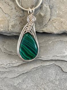 This Malachite necklace is simple yet elegant.  Malachite is a beautiful green color with unique striping/bands of color. I chose to enhance this beautiful smoothstone with a Celtic inspired silver wire design to let the natural beauty of the gemstone shine. This necklace is handmade by me with a synthetic malachite stone The necklace you will receive will be similar to the one in the picture, each stone is unique. The 4th photo in my listing shows the subtle variations of these Beautiful genuin Handmade Green Malachite Necklaces, Green Malachite Handmade Necklace, Handmade Green Malachite Necklace, Green Natural Stone Teardrop Pendant Necklace, Green Teardrop Wire Wrapped Necklace, Green Oval Malachite Necklaces, Green Malachite Wire Wrapped Jewelry, Green Oval Malachite Necklace, Green Wire Wrapped Pendant Necklace