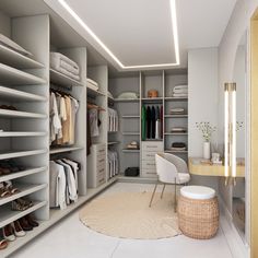 a walk in closet filled with lots of white furniture and shelves next to a desk