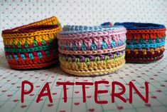 three crocheted baskets sitting on top of a table next to eachother