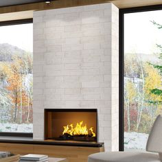 a living room with a fire place in the center and large windows on both sides