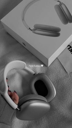 a pair of white headphones sitting on top of a table next to a box