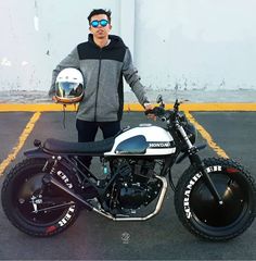 a man standing next to a motorcycle in a parking lot