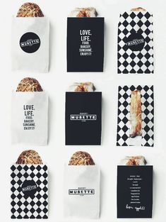 six black and white paper bags with different types of bread in them on a white surface