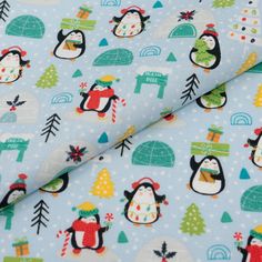 a blue fabric with penguins and trees on it