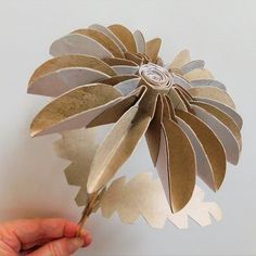 a person holding a paper flower in their hand