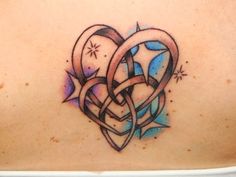 the back of a woman's shoulder with an abstract tattoo design on her chest