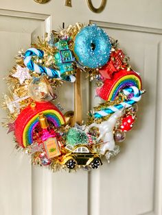 a christmas wreath hanging on the front door decorated with candy, candies and donuts