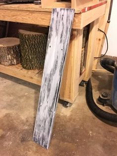 a piece of wood sitting on top of a wooden floor next to a power tool