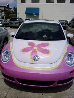 a pink and white car with a flower painted on it