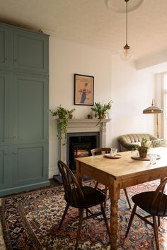 a living room filled with furniture and a fire place next to a fireplace covered in potted plants