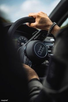 a man is driving his car with the steering wheel up and hands on the dashboard