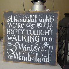 a wooden sign that says, a beautiful sight we're happy tonight walking in a winter wonderland