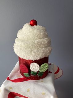 a cupcake decorated with white frosting and red decorations