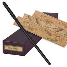 two harry potter's wands are sitting on top of a purple box and one is