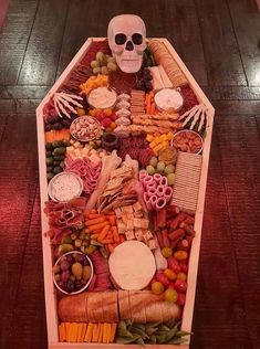 a skeleton sitting on top of a table filled with food