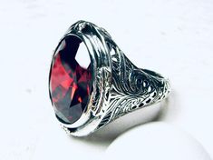 Red Garnet Cubic Zirconia (CZ) Ring  GG Design#2 Custom Made Inspired by Victorian era designs, I now offer this lovely Antique filigree reproduction in sterling silver. There is 4 filigree flowers around the edge of the ring, notice the filigree which extends down the band. This well made setting is sterling silver and is marked 925, approximately 9 grams. This is a stunning Flawless bezel set scarlet red garnet CZ gemstone. The garnet zirconia gemstone a lovely rich scarlet/blood red color and Oval Engraved Red Ruby Ring, Oval Engraved Ruby Ring, Oval Ruby Ring With Engraving, Oval Ruby Ring Engraved, Formal Oval Ruby Ring With Stone Setting, Formal Engraved Red Ruby Ring, Elegant Engraved Red Ruby Ring, Oval Ruby Ring With Vs Clarity, Oval Engraved Ruby Ring Gift