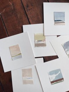 several pieces of paper with different colors and shapes on them sitting on a wooden table