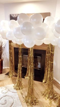 white and gold balloons in front of a fireplace