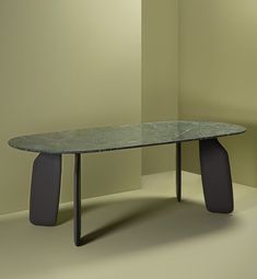 a glass table with two black legs in a room next to a white wall and beige walls