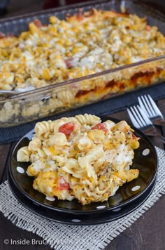 a casserole dish with pasta and vegetables on a black plate