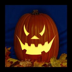 a carved pumpkin sitting on top of leaves