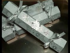 several silver boxes with bows and snowflakes on them