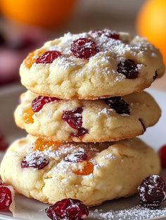 three cranberry orange cookies stacked on top of each other with powdered sugar