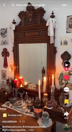 a mirror sitting on top of a wooden table next to candles and other things in front of it