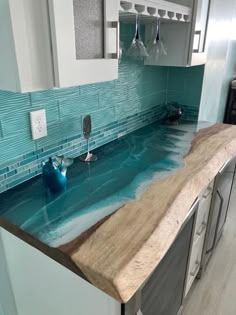 a kitchen counter with blue glass tiles on it