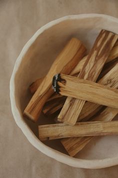 small wooden sticks in a white bowl on a table