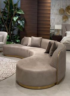 a living room filled with lots of furniture next to a wall mounted plant in the corner