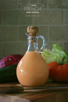 a bottle of dressing next to vegetables on a cutting board