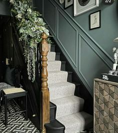 the stairs in this house are decorated with plants and pictures on the wall above them