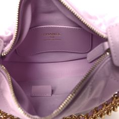 This is an authentic CHANEL Shiny Caviar Quilted Bow Pouch Hobo in Light Purple. This chic classic bag is composed of fine diamond-quilted caviar leather in light purple. This bag features a leather handle with a snap closure, two gold chains with a matching purple bow, and a gold CC logo on the front. The top opens to a purple fabric interior with a flat pocket. Purple Bow, Purple Bows, Classic Bags, Purple Fabric, Cc Logo, Light Purple, Leather Handle, Gold Chains, Chanel