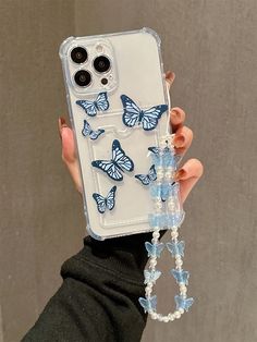 a person holding up a phone case with butterflies on it and beads hanging from the back