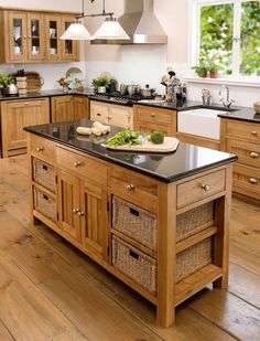 a large kitchen with wooden cabinets and black counter tops, an island in the middle