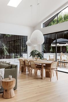 a living room filled with furniture and a dining table next to a large glass window