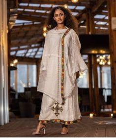 This stunning Ethiopian Habesha dress is made with handwoven Menen fabric, known for its luxurious feel and traditional craftsmanship. The vibrant colors of the dress, paired with intricate Tilf embroidery at the neckline and wrists, make for a truly eye-catching piece. The dress is designed to be comfortable and flattering, with a flowing skirt and flattering waistline. Perfect for any special occasion, this dress is a true testament to the beauty and richness of Ethiopian fashion. PLEASE ADD Y Luxury Women's Festive Habesha Kemis, African Men Fashion Shirts, Ethiopian Fashion, Eritrean Dress, Ethiopian Clothing, Habesha Dress, Ethiopian Traditional Dress, Ethiopian Women, Ethiopian Dress