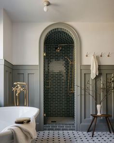 a bathroom with a black and white checkered floor, gray walls and an arched doorway