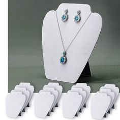 a necklace and earring set with turquoise stones on display in front of white tags