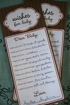 two brown and white baby shower bookmarks with handwritten wishes for babies on them