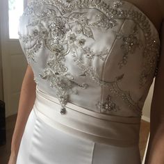 the back of a woman's wedding dress with beading on it