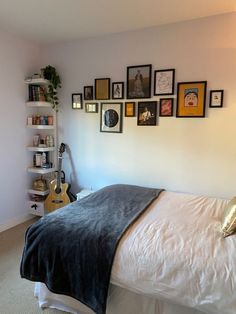 a bedroom with white walls and pictures on the wall