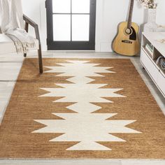 a brown and white area rug with an acoustic guitar on the floor next to it