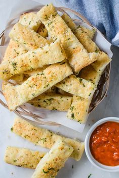 garlic bread sticks in a basket with dipping sauce