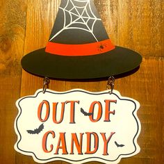 a sign that says out of candy with a witch's hat hanging from it